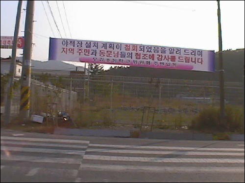 학교 정문 입구에 걸린 야적장 철회 안내 현수막 